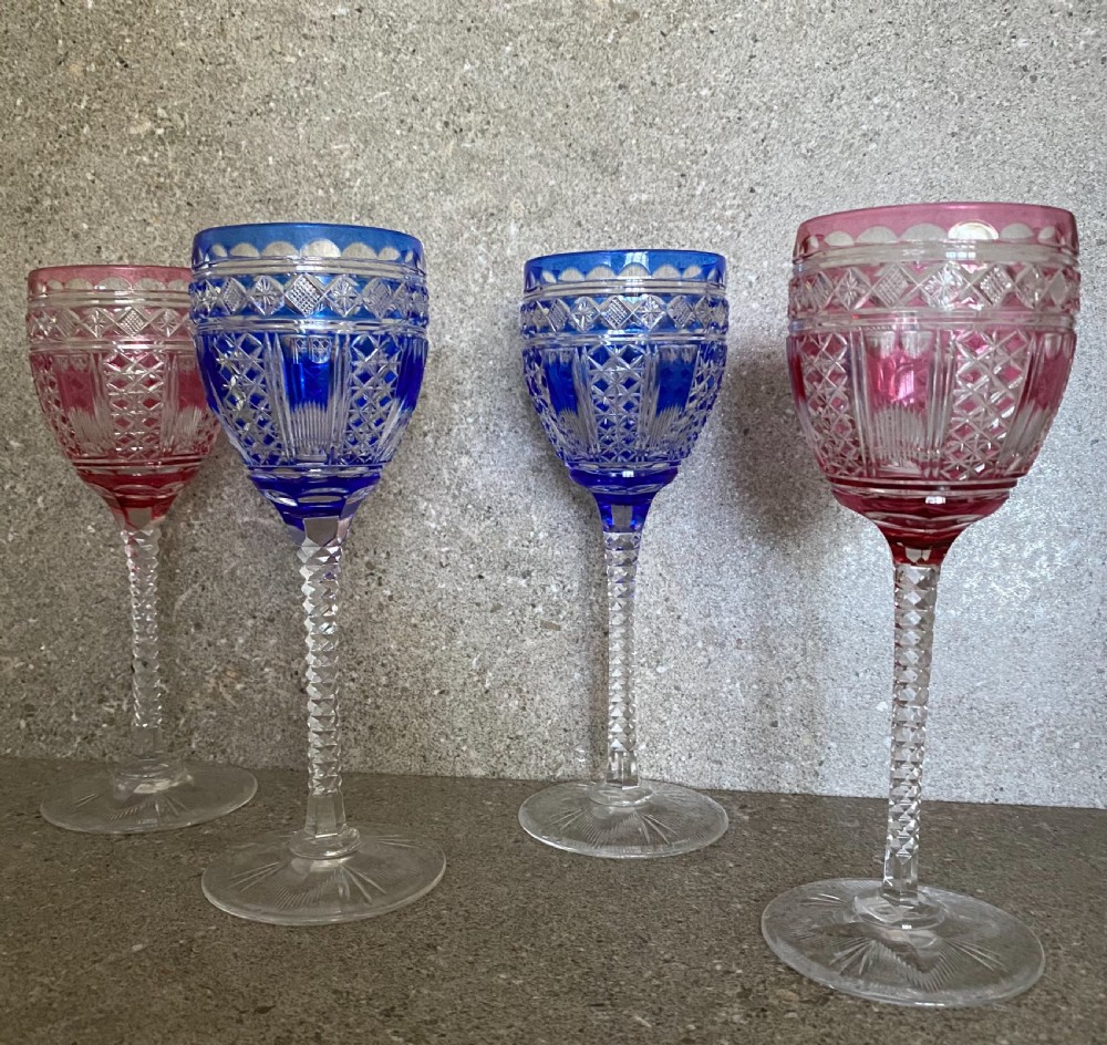 A set of six cut-to-clear crystal wine glasses with alternating cobalt blue and ruby red bowls on tall faceted stems. View VII