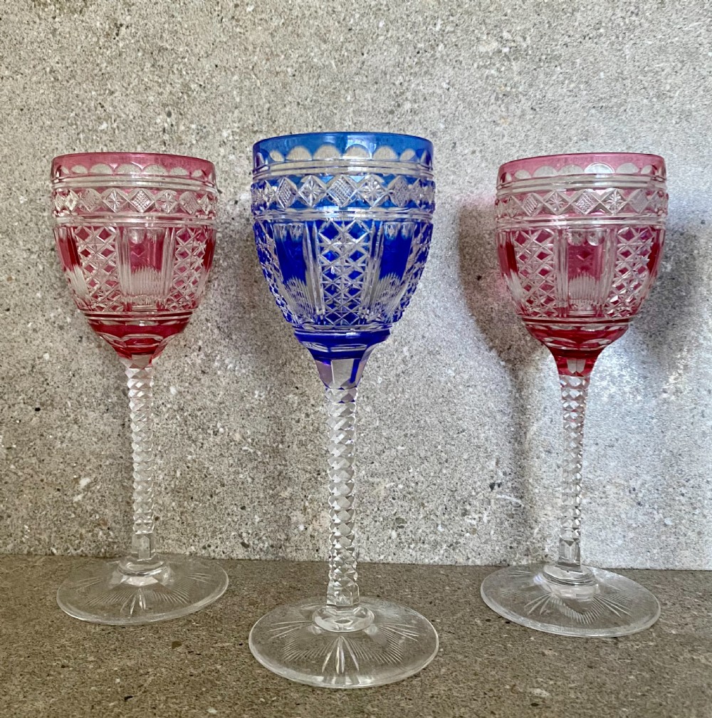 A set of six cut-to-clear crystal wine glasses with alternating cobalt blue and ruby red bowls on tall faceted stems. View VIII