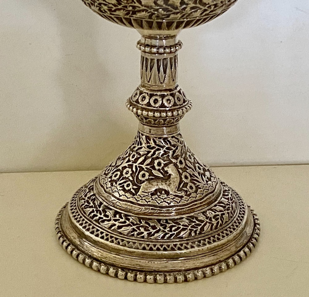 A 19th-century Indian Kutch silver trophy cup featuring dense chased floral motifs, twin scrolled handles, and an engraved central cartouche. View VIII