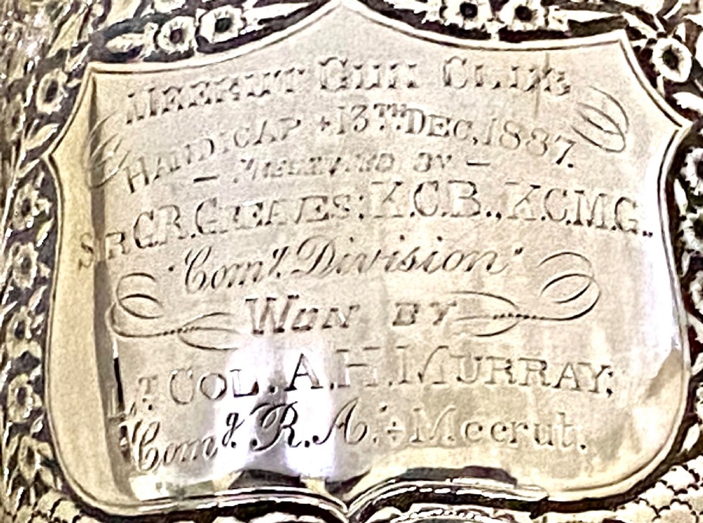A 19th-century Indian Kutch silver trophy cup featuring dense chased floral motifs, twin scrolled handles, and an engraved central cartouche. View IX