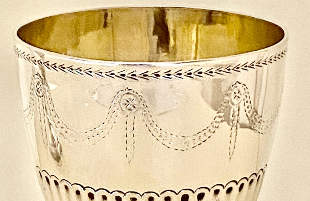 An 18th-century Georgian sterling silver goblet featuring bright-cut festoon engraving, lower bowl fluting, and a circular beaded pedestal foot. View IV