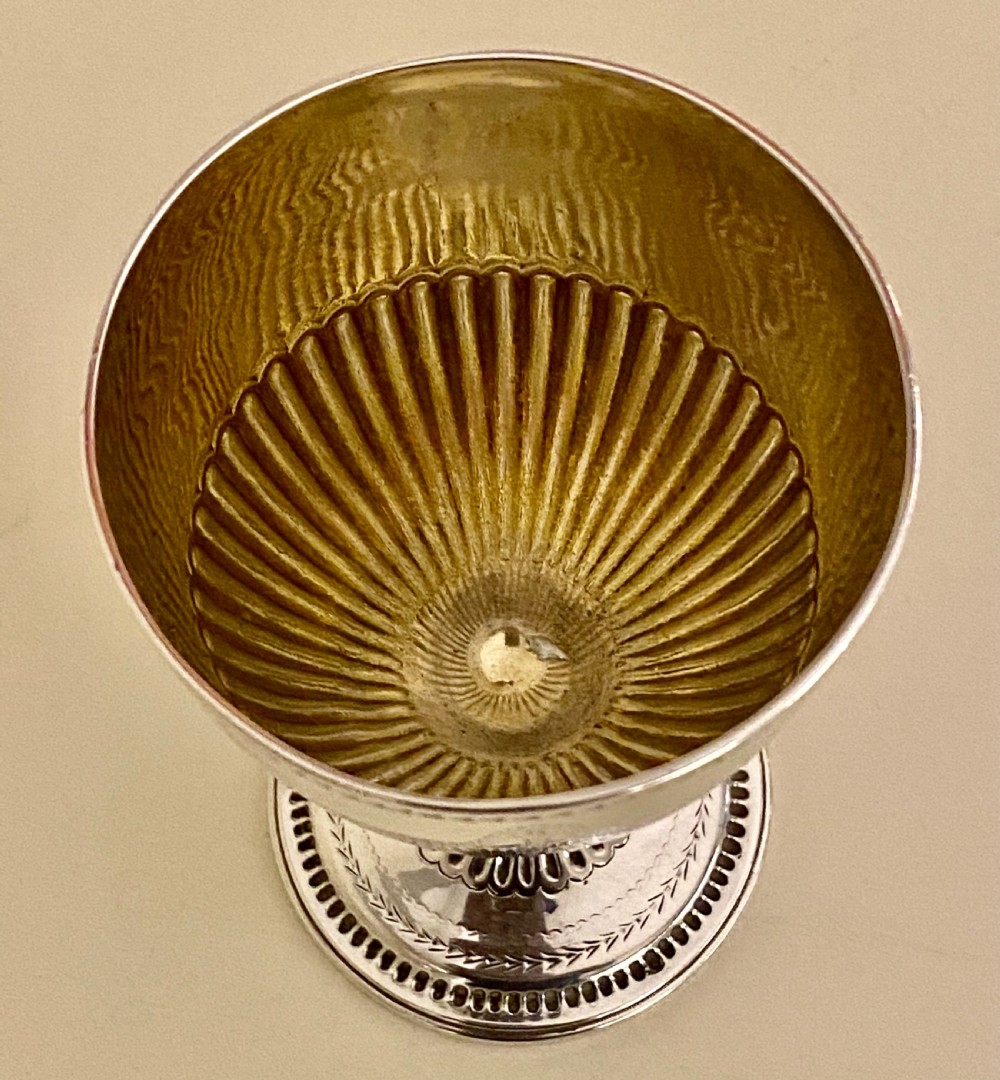 An 18th-century Georgian sterling silver goblet featuring bright-cut festoon engraving, lower bowl fluting, and a circular beaded pedestal foot. View VI
