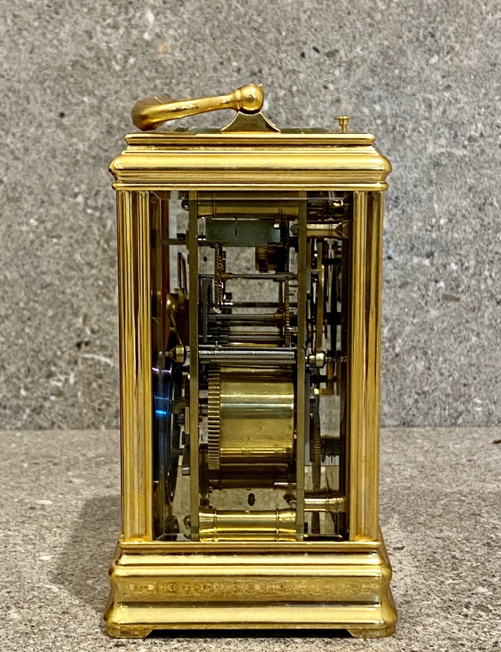 A nineteenth-century gilt brass repeating carriage clock featuring a white enamel dial with Roman numerals, a subsidiary alarm dial, glass side panels, and a hinged top handle. View III