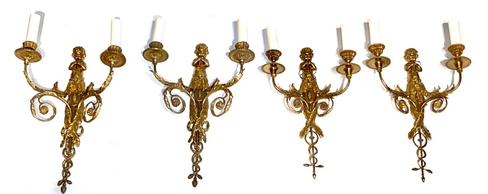 Set of four French gilt bronze two-branch wall sconces featuring central cherub figures and scrolling candle arms. View IV