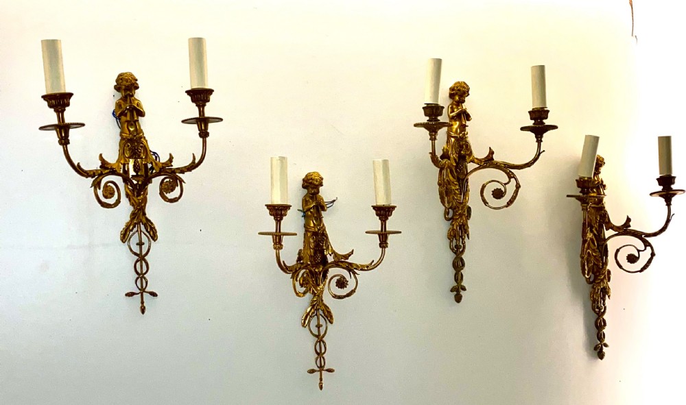Set of four French gilt bronze two-branch wall sconces featuring central cherub figures and scrolling candle arms. View VI