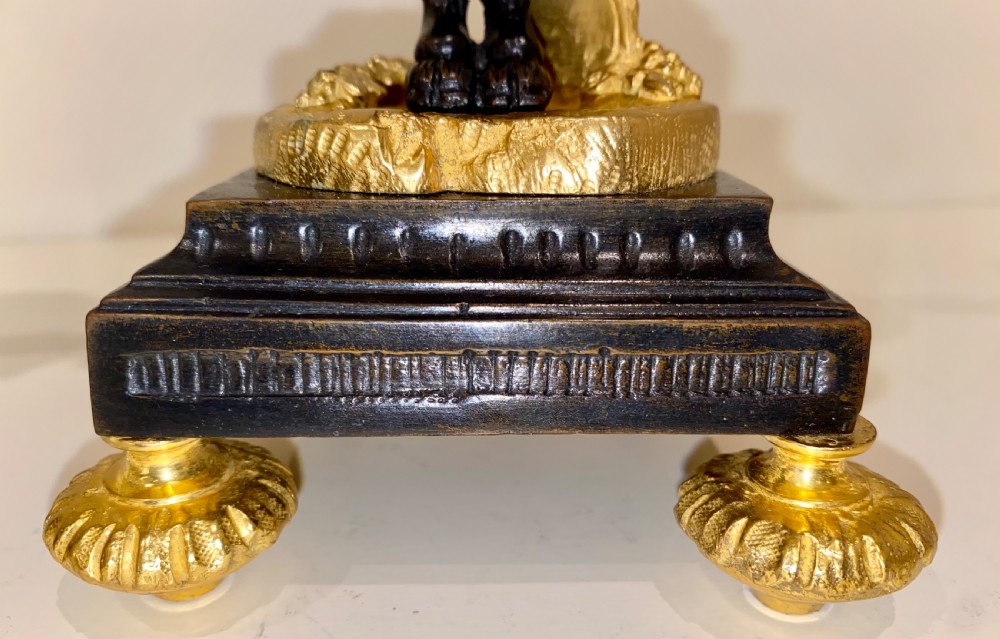 A pair of antique French gilt and patinated bronze two-light candelabra featuring dark bronze cherub figures holding gold candle arms on square bases. View XV