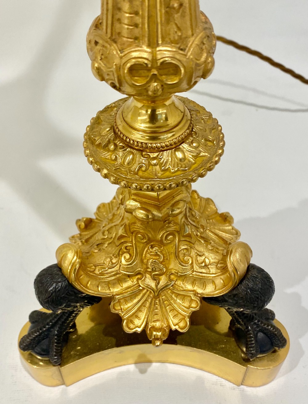 A 19th-century French Empire parcel-gilt and patinated bronze candelabra lamp with a fluted shaft, multiple candle arms, and a tripod paw base. View IV