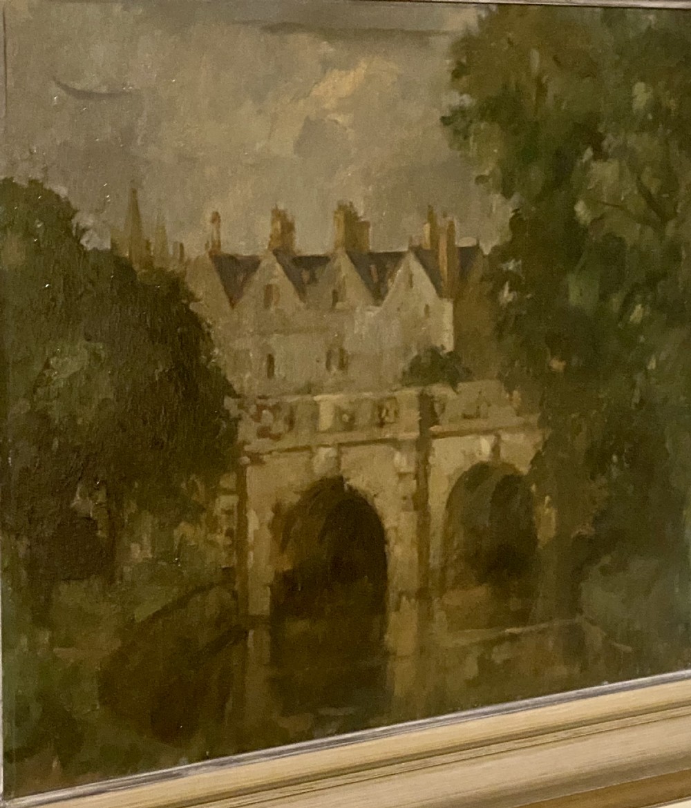 A framed oil painting on board depicting Magdalene Bridge in Oxford, featuring stone arches over water surrounded by trees and classical architecture. View V