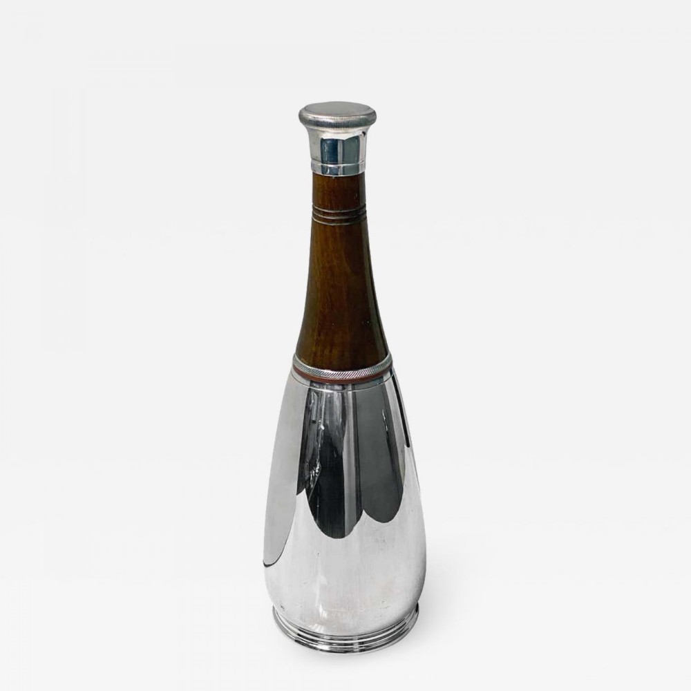 An Art Deco silver-plated cocktail shaker crafted in a bottle shape with a dark turned wood neck and silver stopper cap.