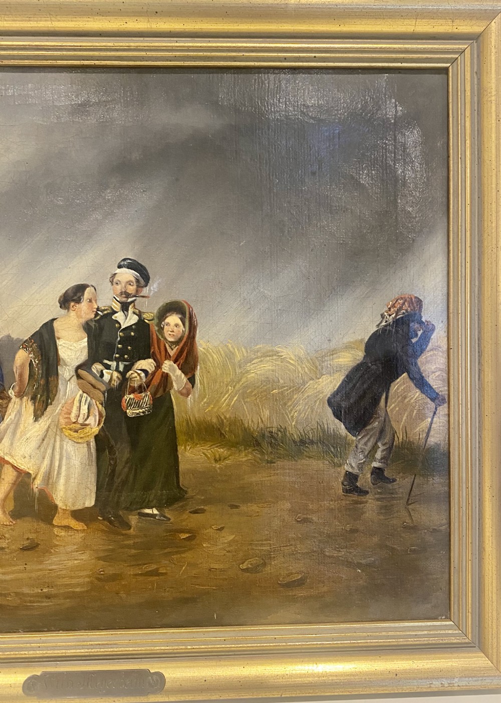 A 19th-century oil painting depicting several figures walking through rain under an umbrella, housed in a moulded gold frame. View V