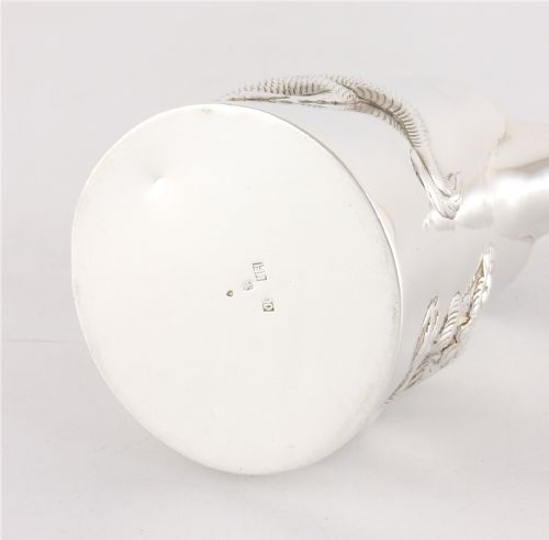 fig 2. A silver jug with a repousse dragon around the body and a handle shaped like bamboo.