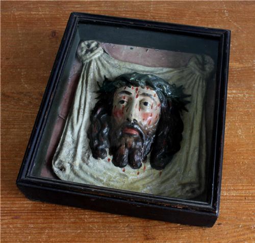 fig 2. A high-relief polychrome sculpture depicting the Veil of Veronica with the face of Jesus wearing a crown of thorns, presented inside a black glazed wooden shadowbox frame.