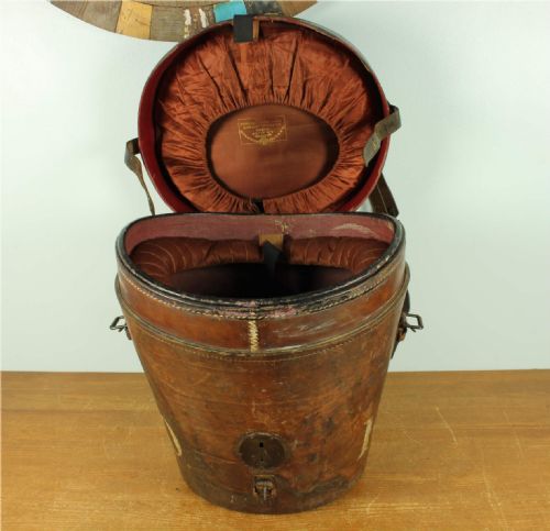 fig 2. A dark brown antique leather double hat box featuring a top carrying strap, buckled securing straps, and hand-stitched details.