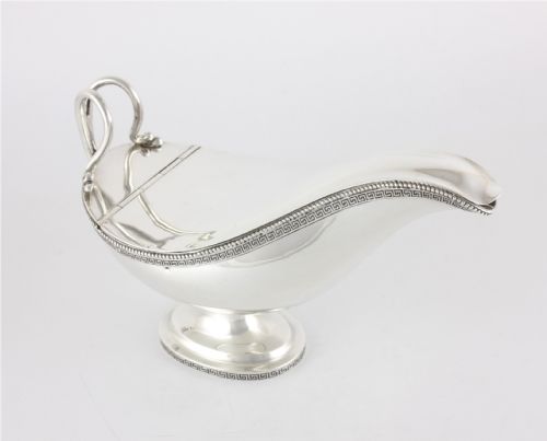 fig 2. A nineteenth-century sterling silver lidded sauce boat featuring a Greek key border, beaded rim, double-scroll handle, and a pedestal foot.