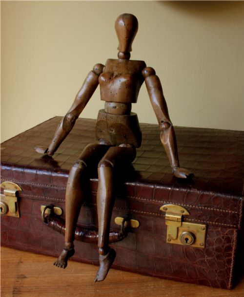 fig 1. A carved 19th-century wooden articulated female artist lay figure shown sitting down with fully jointed limbs and a stylised head.