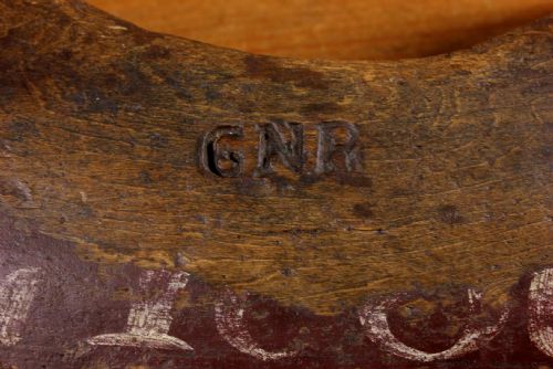 fig 1. A carved dark wood railway shoulder yoke with original hand-painted lettering showing station and company markings.