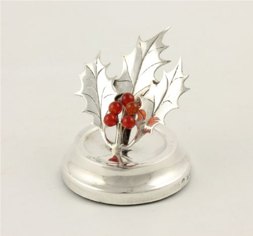 fig 1. An Edwardian sterling silver menu holder designed as holly leaves with red agate berries set upon a circular stepped base.
