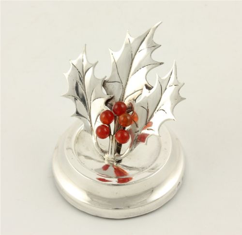 fig 2. An Edwardian sterling silver menu holder designed as holly leaves with red agate berries set upon a circular stepped base.