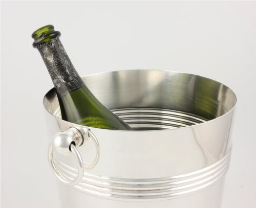 fig 2. A silver-plated cylindrical champagne cooler featuring horizontal ribbed banding and two side ring handles attached via spherical mounts.