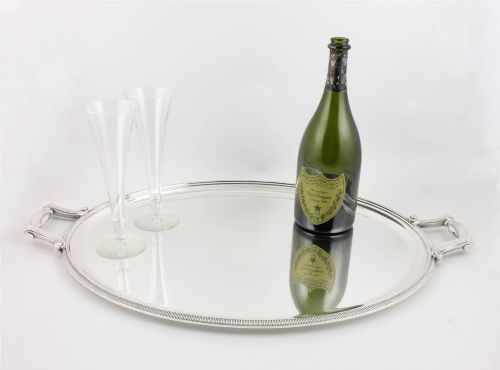 fig 1. An extra large oval silver-plated tray with reeded border detail and two outer scroll handles on a plain background.