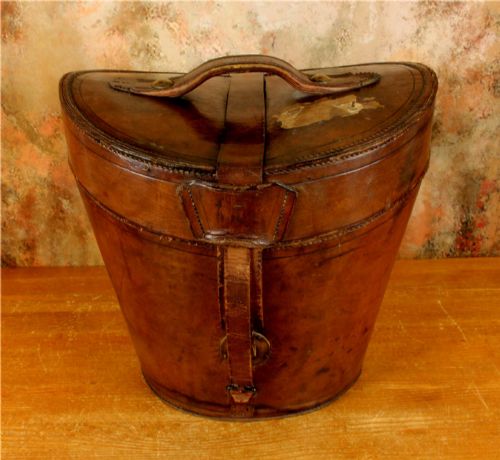 fig 1. An open Victorian brown leather hat case featuring a padded bright red quilted silk lining and removable hat support collars.