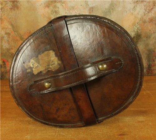 fig 2. An open Victorian brown leather hat case featuring a padded bright red quilted silk lining and removable hat support collars.