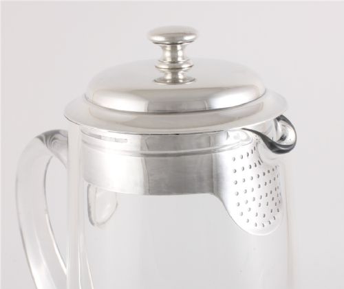 A clear glass water jug with a silver-plated hinged lid, integrated strainer spout, and curved glass handle. View VIII