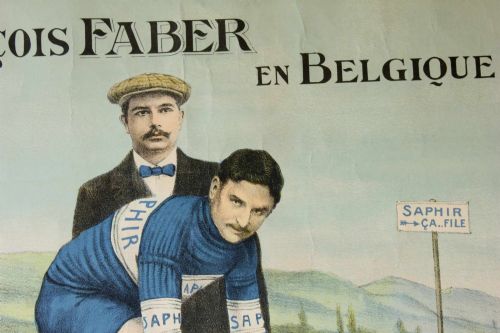 fig 1. An early twentieth-century Belgian advertising poster depicting cyclist Francois Faber aboard a blue bicycle with French text and a landscape background.