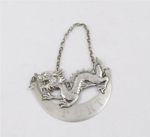 fig 2. An antique Chinese silver decanter label depicting a chased dragon above a crescent plaque engraved with PORT, attached to a chain.