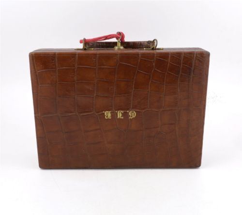 fig 3. An open brown crocodile leather jewellery case featuring a green velvet lined interior with multiple compartments and brass lock hardware.