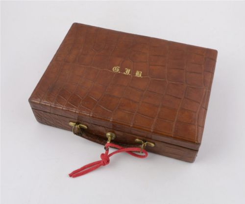 fig 4. An open brown crocodile leather jewellery case featuring a green velvet lined interior with multiple compartments and brass lock hardware.