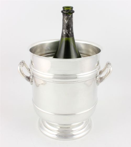 fig 2. A polished silver-plated champagne cooler featuring side handles with leaf detailing and a stepped pedestal base.