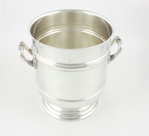 fig 4. A polished silver-plated champagne cooler featuring side handles with leaf detailing and a stepped pedestal base.