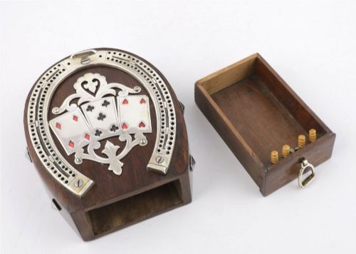 fig 2. An antique horseshoe-shaped dark oak games box featuring silver metal scrollwork, playing card motifs, and an integrated cribbage scoring track.