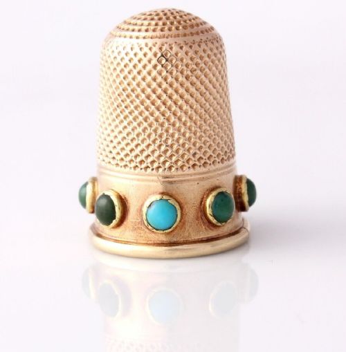 fig 1. An antique Victorian 15ct gold thimble with turquoise cabochon studs displayed inside an open red leather velvet-lined case.