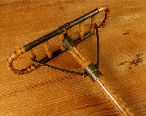 fig 3. A late 19th-century bamboo shooting stick featuring a folding seat handle, metal support struts, and a spiked metal base.