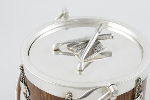 fig 2. A cylindrical English oak ice pail shaped like a military drum, featuring silver-plated trim, rope-work detailing, a swing handle, and a lid topped with crossed drumsticks.