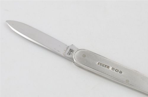 fig 3. A vintage hallmarked sterling silver letter opener featuring an engine-turned handle casing with an integrated folding knife blade.