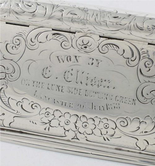fig 3. An engraved Victorian sterling silver rectangular snuff box featuring intricate foliate scrollwork and inscribed presentation text.