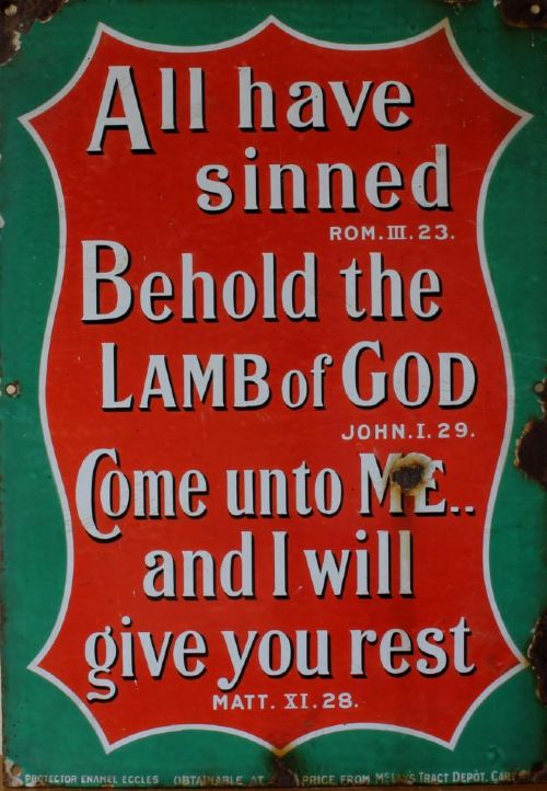 A rectangular vitreous enamel sign with a green background and a red central cartouche displaying white and black printed scripture texts. View V