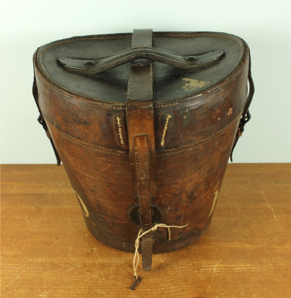 A dark brown antique leather double hat box featuring a top carrying strap, buckled securing straps, and hand-stitched details.