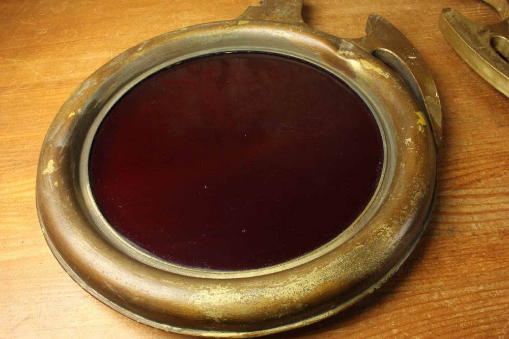 An antique brass optician trade sign in the form of oversized pince-nez spectacles, featuring one red glass lens and one dark blue glass lens. View VIII