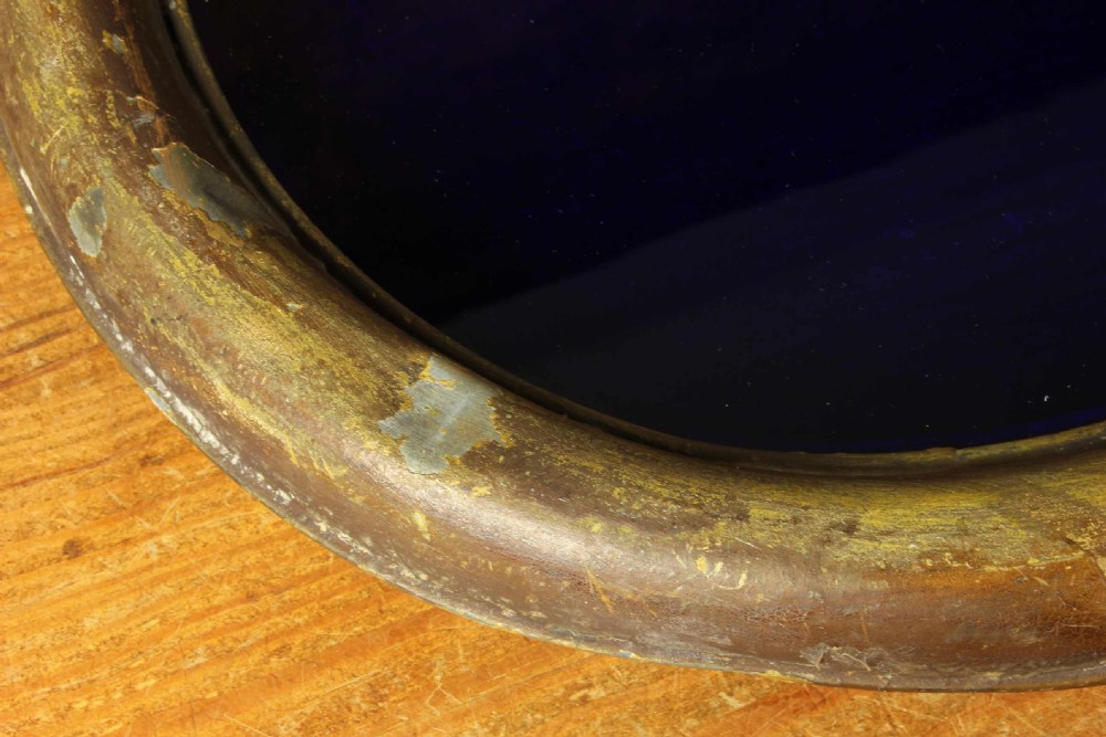An antique brass optician trade sign in the form of oversized pince-nez spectacles, featuring one red glass lens and one dark blue glass lens. View XX