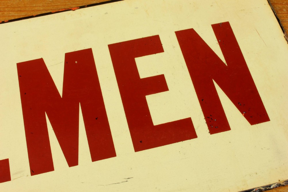 An antique rectangular off-white vitreous enamel sign displaying bold burgundy typography reading GENTLEMEN with patinated edges. View VII