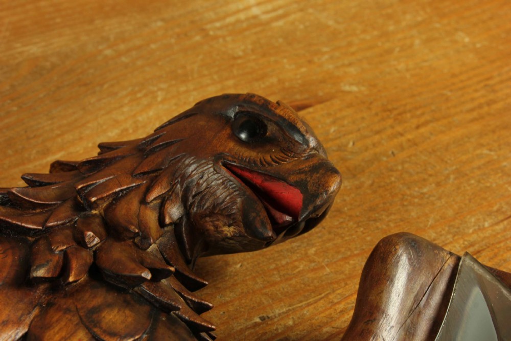 A hand-carved dark wood wall mirror crafted in the form of an eagle with outstretched wings framing a circular glass mirror plate. View XII