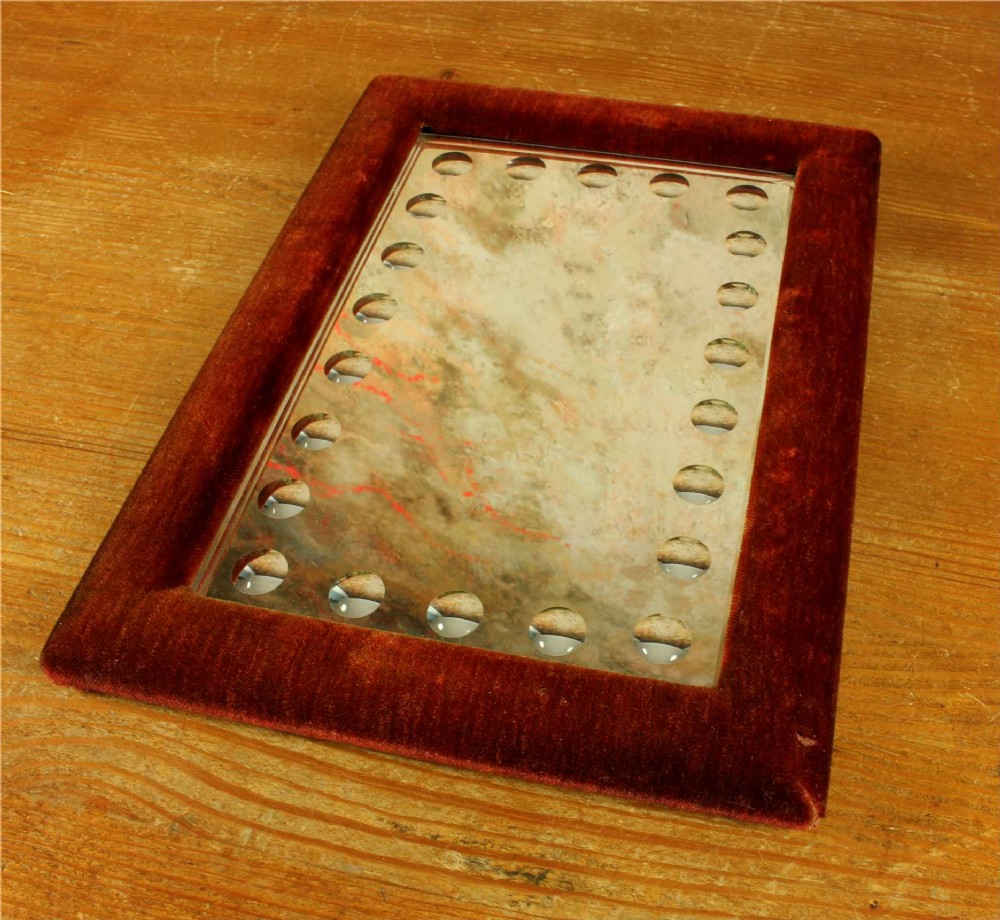 A rectangular Victorian wall mirror featuring a red velvet frame and a perimeter of circular convex lenses cut into the glass. View VI
