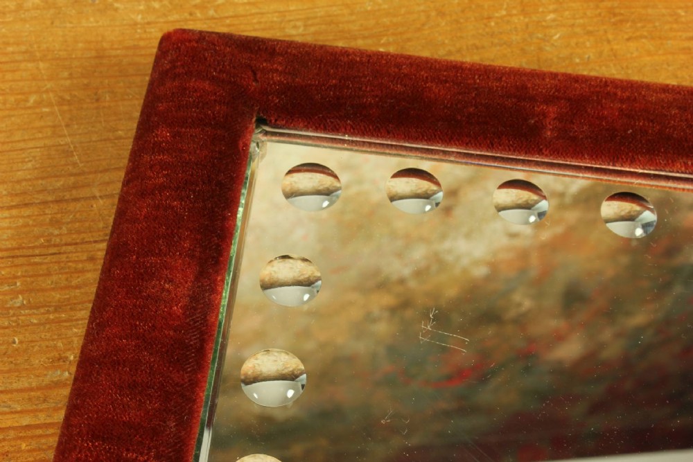 A rectangular Victorian wall mirror featuring a red velvet frame and a perimeter of circular convex lenses cut into the glass. View VIII