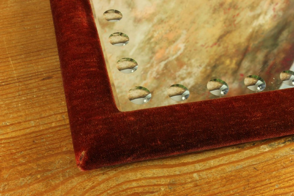 A rectangular Victorian wall mirror featuring a red velvet frame and a perimeter of circular convex lenses cut into the glass. View IX