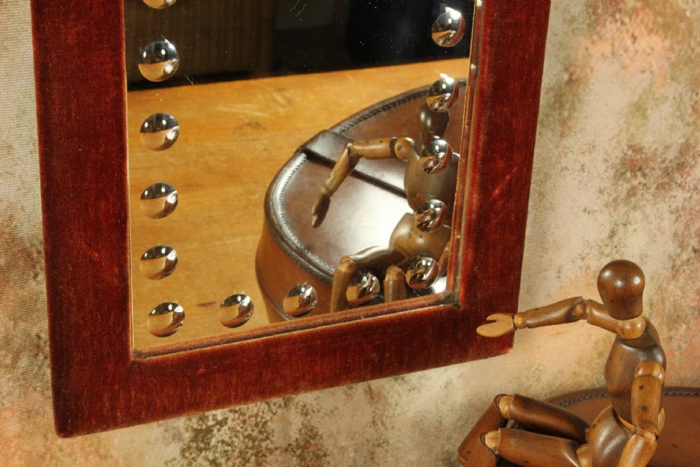 A rectangular Victorian wall mirror featuring a red velvet frame and a perimeter of circular convex lenses cut into the glass. View XII