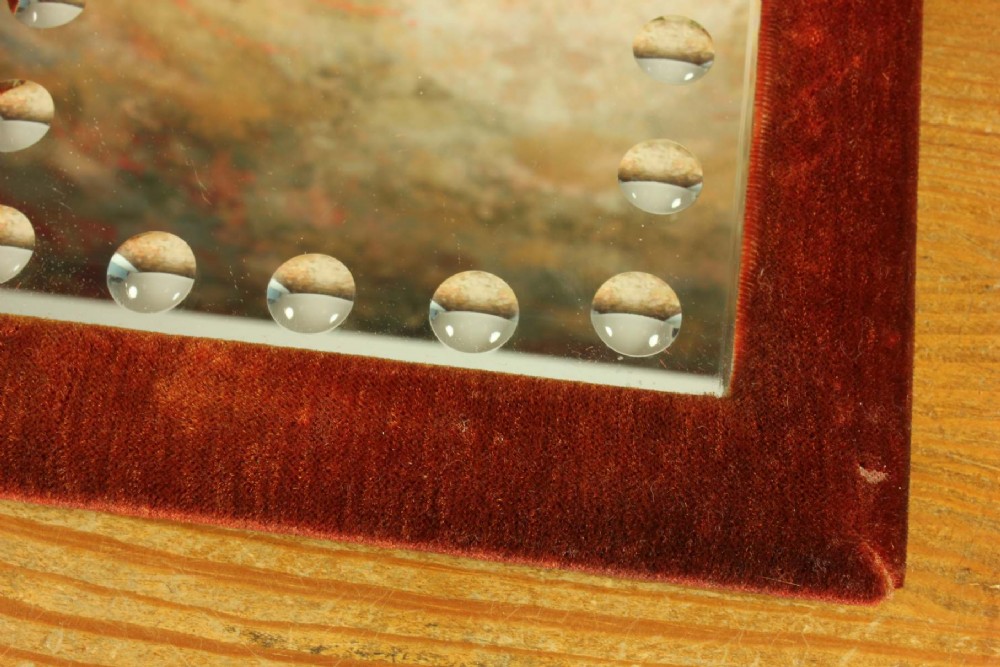 A rectangular Victorian wall mirror featuring a red velvet frame and a perimeter of circular convex lenses cut into the glass. View XV